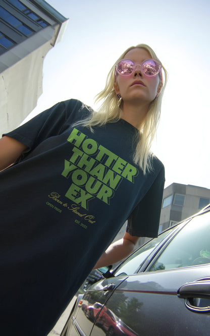 Junge Frau in Urbaner Umgebung trägt grünes, nachhaltiges Streetwear Shirt hotter than your ex
